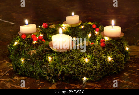 Advent Weihnachten Kerzen Kranz Abend aus dunklem Holz Moss Stockfoto