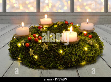 Advent Weihnachten Kerzen Kranz Abend aus dunklem Holz Moss Stockfoto