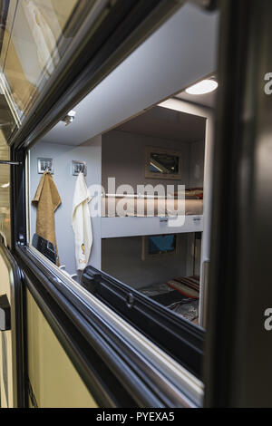 Draußen stehen und schauen durch ein Fenster einer Karawane, Schweiz Stockfoto