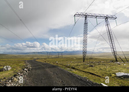 Isländische Landschaft mit leeren Piste und Hochspannungsleitungen. Stockfoto