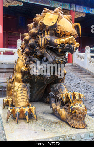 In der Nähe der traditionellen vergoldeten weiblichen Imperial guardian Löwe, ein Baby in die berühmte Verbotene Stadt, Peking, China Stockfoto