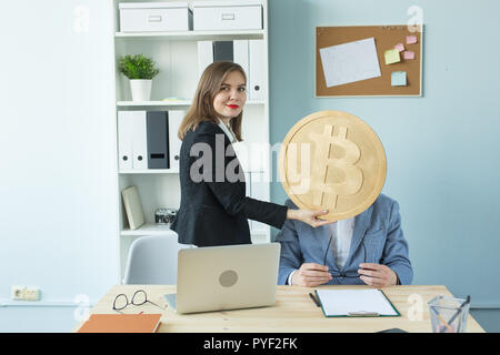 Geld, crypto Währung und Personen Konzept-business Frau Gesicht des Mannes geschlossen durch riesige Bitcoin im Büro Stockfoto