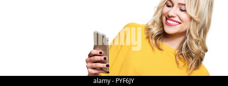 Wunderschöne lächelnde Frau an ihrem Handy suchen. Frau sms auf ihrem Handy, isoliert auf weißem Hintergrund. Banner mit kopieren. Stockfoto