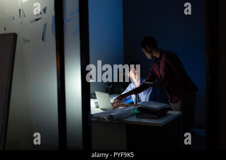 Führungskräfte sprechen über Laptop Stockfoto