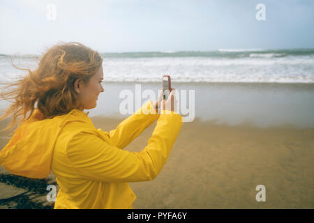 Frau Klick Fotos mit Handy in den Strand Stockfoto