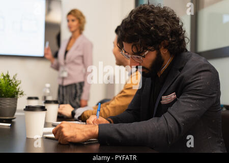 Männliche executive Schreiben auf Notepad Stockfoto