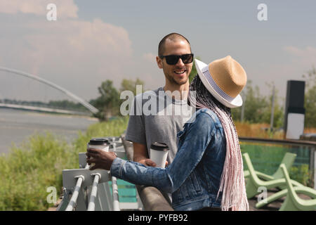 Paar mit Kaffee Tasse steht in der Nähe der Geländer Stockfoto