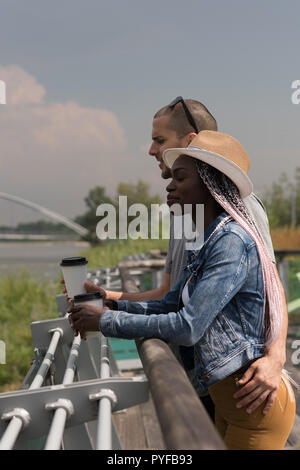 Paar mit Kaffee Tasse steht in der Nähe der Geländer Stockfoto