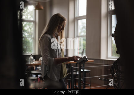 Arbeitnehmerin, die Maschine im Werk in Betrieb Stockfoto