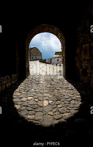 Kurvige Form der Eingang der Berat Schloss in Albanien, sonnigen Frühling Tag mit Stone Street, Schatten und trübe Frühlingshimmel Stockfoto