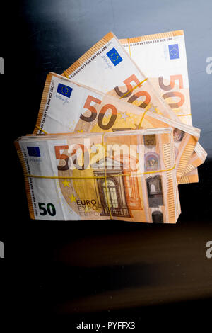 Stapel von 50 echten Euro-Banknoten 50-Euro-Banknoten unter Gummiband isoliert auf Schwarz. Über 20000 Euro wert. Stockfoto