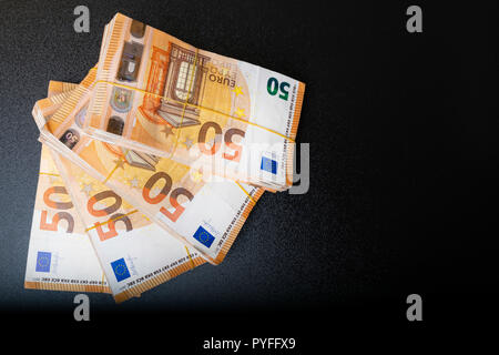 Stapel von 50 echten Euro-Banknoten 50-Euro-Banknoten unter Gummiband isoliert auf Schwarz. Über 20000 Euro wert. Stockfoto