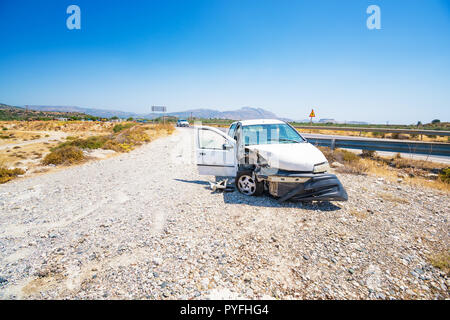 Vor zerschmetterte Auto nach Unfall, hinter der Barriere auf der Straße, sonnigen Tag abgestürzt Stockfoto