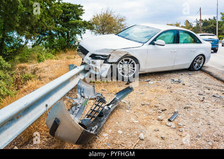 Zerschmetterte Auto mit deflationiert Airbags nach Unfall auf der Straße fertig Barriere abgestuerzt Stockfoto