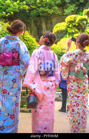 Kamakura, Japan - 23. April 2017: Zurück der japanischen Damen in Zen Garten, in traditionellen Kimonos in rosa gekleidet Takera Hokoku-ji Temple von Kamakura. Die selfie der Schönheit des Zen Garten, vertikaler Stockfoto