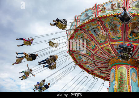 Buntes Karussell an bewölkten Himmel Hintergrund. Oktoberfest, Bayern, Deutschland Stockfoto