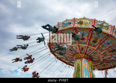 Buntes Karussell an bewölkten Himmel Hintergrund. Oktoberfest, Bayern, Deutschland Stockfoto