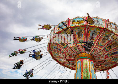 Buntes Karussell an bewölkten Himmel Hintergrund. Oktoberfest, Bayern, Deutschland Stockfoto