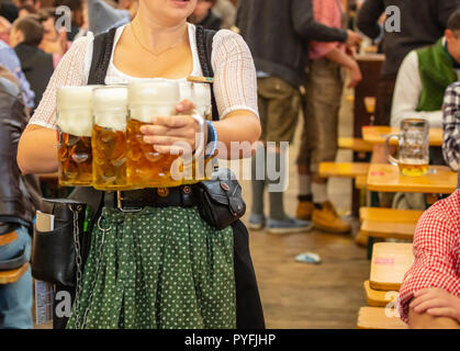 Oktoberfest, München, Deutschland. Frau Kellner mit traditionellen Kostüm holding Biere Stockfoto