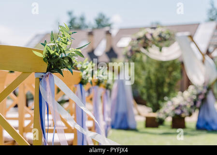 Stühle aus Holz bei einer Hochzeit. Die Stühle mit Knopflöchern und Bänder für Gäste eingerichtet Stockfoto