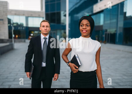Business-frau und Geschäftsmann mit Laptops in den Händen im freien, modernen Bürogebäude auf Hintergrund, Partnerschaft Verhandlungen während der Mittagspause. Stockfoto