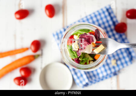 Blick von oben auf die gesunden Salat in einem Glas auf weiße Holztisch Stockfoto