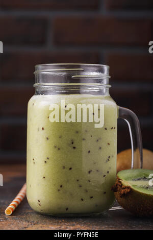 Hausgemachten Smoothie aus reifen Kiwis in einem Glas mit Obst auf den Tisch gestellt Stockfoto