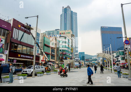 Ein Blick hinunter Gunam-ro In Haeundae, Busan, Südkorea als Handwerker eine neue Verkleidung an der Vorderseite der Shop an. Stockfoto