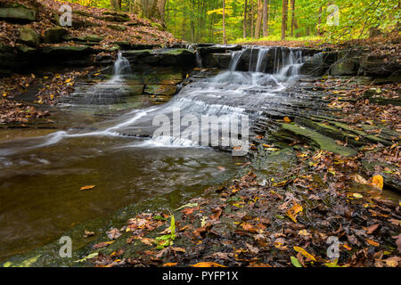 Eine der vielen malerischen Wasserfällen entlang der Sulpher Springs Creek in Bentleyville Ohio während der Spitzenzeiten fallen Farben. Dieser kleine Wasserfall sieht es am Besten w Stockfoto