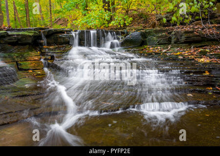 Eine der vielen malerischen Wasserfällen entlang der Sulpher Springs Creek in Bentleyville Ohio während der Spitzenzeiten fallen Farben. Dieser kleine Wasserfall sieht es am Besten w Stockfoto