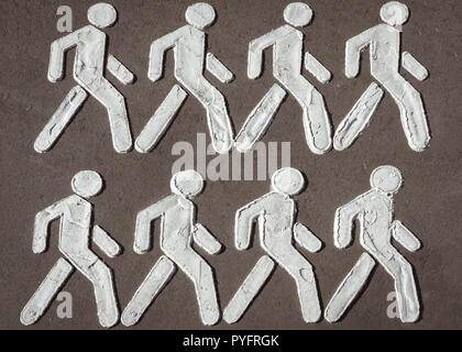 Symbole der Männer Gruppe Wandern in einer Zeile auf der Asphaltstraße Sinne Fußgänger wandern Ort gemalt. Konzept nach einer Richtung oder folgenden Stockfoto