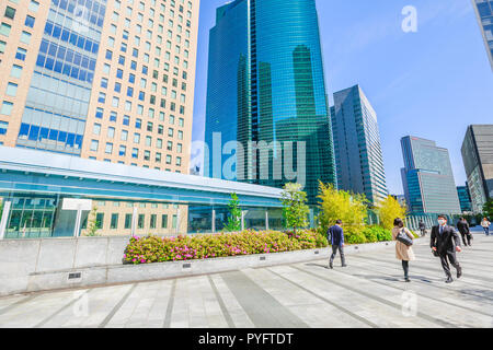 Tokyo, Japan - 20. April 2017: Tokyo städtische Unternehmer gehen in Shiodome, mit hohen Wolkenkratzer in Shinbashi Finanzviertel. Yurikamome Monorail in Shiodome entfernt. Stockfoto