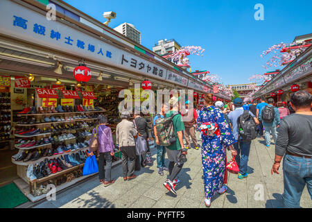 Tokyo, Japan - 19. April 2017: Masse der Leute im Frühjahr Sakura auf nakamise-dori, Straße mit Lebensmitteln und Souvenirs Geschäfte, connetting die Kaminarimon Präfektur Tor am Eingang von Senso-ji Buddhistischer Tempel. Stockfoto