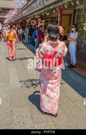 Tokyo, Japan - 19. April 2017: Frauen tragen Kimonos, die nationale Tradition Kostüm von Japan, zu Fuß auf nakamise-dori, einer Straße mit Lebensmitteln und Souvenirläden. Buddhistischen Tempel Senso-ji in Asakusa. Stockfoto