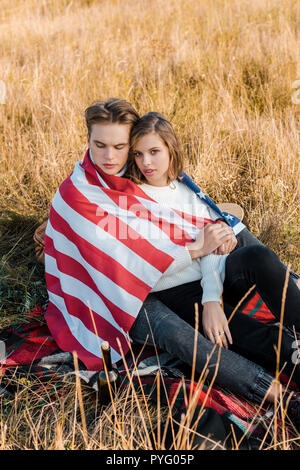 Junges Paar mit amerikanischen Flagge auf Plaid, Tag der Unabhängigkeit Konzept Stockfoto