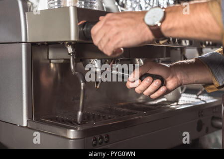 7/8 Schuß von Barista mit Kaffeemaschine im Restaurant Stockfoto