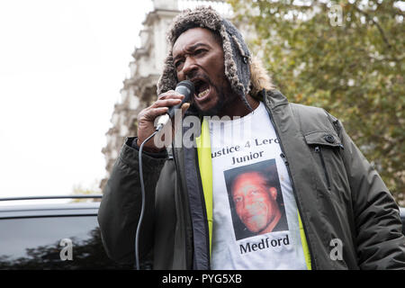 London, Großbritannien. 27. Oktober, 2018. Dennis Medford, Bruder von Leroy 'Junior' Medford, Adressen Aktivisten aus den Vereinigten Familien und Freunde Kampagne (UFFC) die Teilnahme an der 20. jährlichen Prozession zur Downing Street in Erinnerung an Familienmitglieder und Freunde, die in Polizeigewahrsam, Gefängnis starb, Immigration Detention oder Secure psychiatrische Krankenhäuser. Junior Medford, 43, starb an einer Überdosis Heroin an der Canterbury Tales Polizeistation am 2. April 2017. Credit: Mark Kerrison/Alamy leben Nachrichten Stockfoto