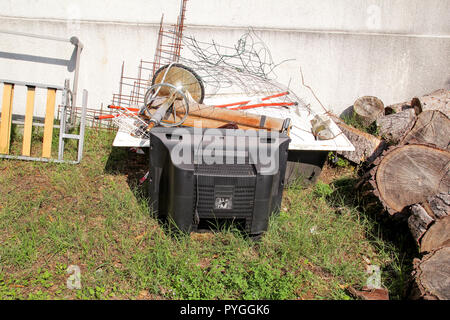 Alte Fernseher und den Rest von sperrigen Müll. Alter FERNSEHER weggeworfen neben einer Wand mit einem Stapel von gemischten Müll. in natürlicher Umgebung. Recycling Industrie. Stockfoto