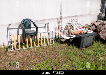 Alte Fernseher und den Rest von sperrigen Müll. Alter FERNSEHER weggeworfen neben einer Wand mit einem Stapel von gemischten Müll. in natürlicher Umgebung. Recycling Industrie. Stockfoto