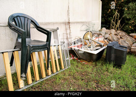 Alte Fernseher und den Rest von sperrigen Müll. Alter FERNSEHER weggeworfen neben einer Wand mit einem Stapel von gemischten Müll. in natürlicher Umgebung. Recycling Industrie. Stockfoto