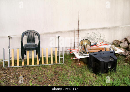 Alte Fernseher und den Rest von sperrigen Müll. Alter FERNSEHER weggeworfen neben einer Wand mit einem Stapel von gemischten Müll. in natürlicher Umgebung. Recycling Industrie. Stockfoto