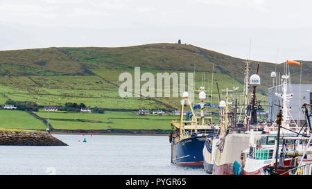 Dingle, Kerry/Irland - 22. September 2018: Fischerboote im Hafen von Dingle mit irischen Landschaft über die Bucht vor Anker Stockfoto