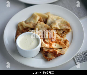 Makro Foto von dünnen leckere Pfannkuchen mit Vanille Creme auf einer weißen Platte Stockfoto