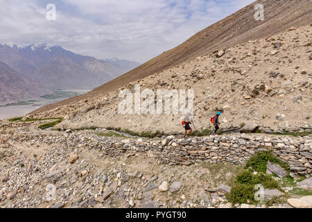 Wanderer Wandern der wunderschöne Engels Peak Hill trek neben einem traditionellen Pamiri Deich, oder Wasser Kanal, Langar, tadschikischen Wakhan, Pamir, Taj Stockfoto