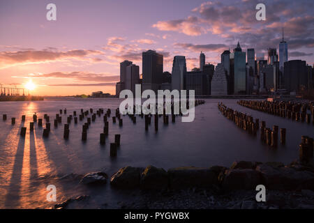 Sonnenuntergang in Manhattan, NY; aus Brooklyn Bridge Park gesehen, die Skyline von Lower Manhattan bei Sonnenuntergang Stockfoto