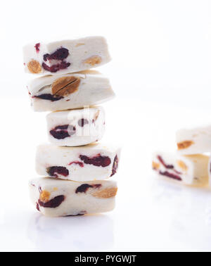 Sorft weißer Nougat mit Mandeln und Preiselbeeren auf weißem Hintergrund Stockfoto