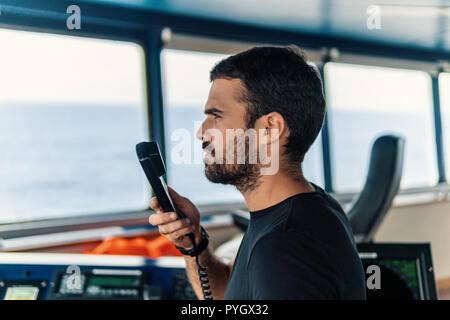 Marine nautischer Offizier ist Berichterstattung von UKW-Radio Stockfoto