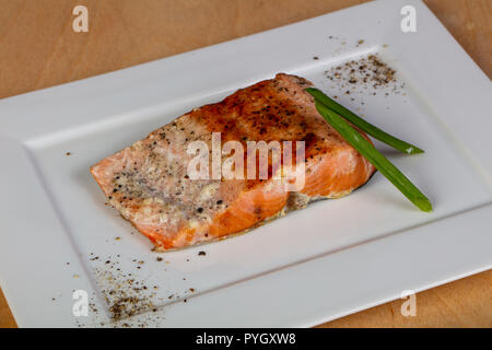 Gebratenes Lachssteak serviert grüne Zwiebel Stockfoto