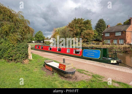 Schmale Boot und Sitzgelegenheiten in der Form eines schmalen Boot auf dem Trent und Mersey Canal in Northwich Cheshire UK Stockfoto