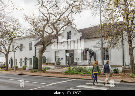 Stellenbosch, Südafrika, 16. AUGUST 2018: Historische Gebäude in Dorp Street in Stellenbosch in der Western Cape Provinz. Ein bergmann Statue und Menschen Stockfoto